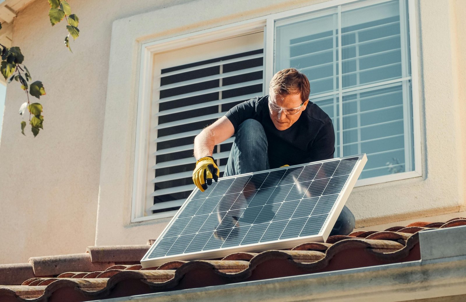 Asesorías para Crecimiento y Producción en Cataluña Solar technician installing a photovoltaic panel on a rooftop, promoting renewable energy.